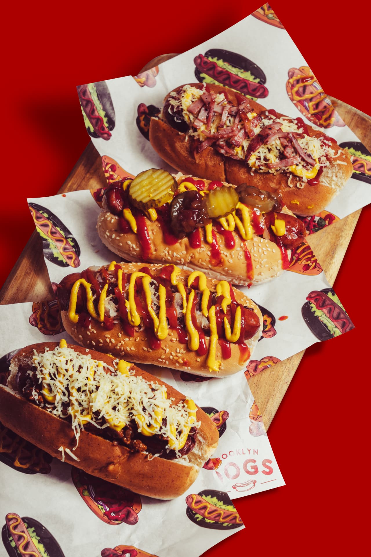 A lineup of Brooklyn Dogs gourmet hot dogs on branded paper