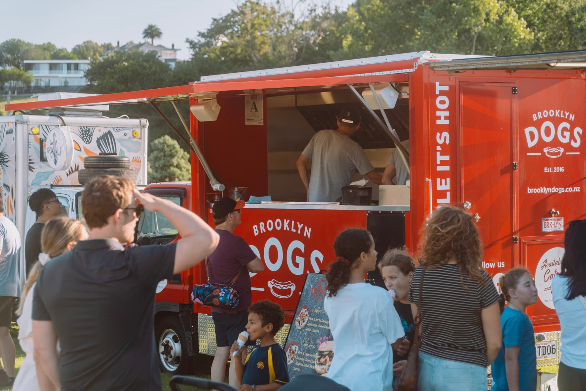 A crowd queuing at the Brooklyn Dogs truck serving hatch